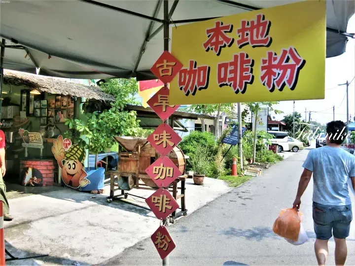 Yellow sign reading Local Coffee Powder and red diamond signs for Kwo Zha B Coffee at a roadside stall.
