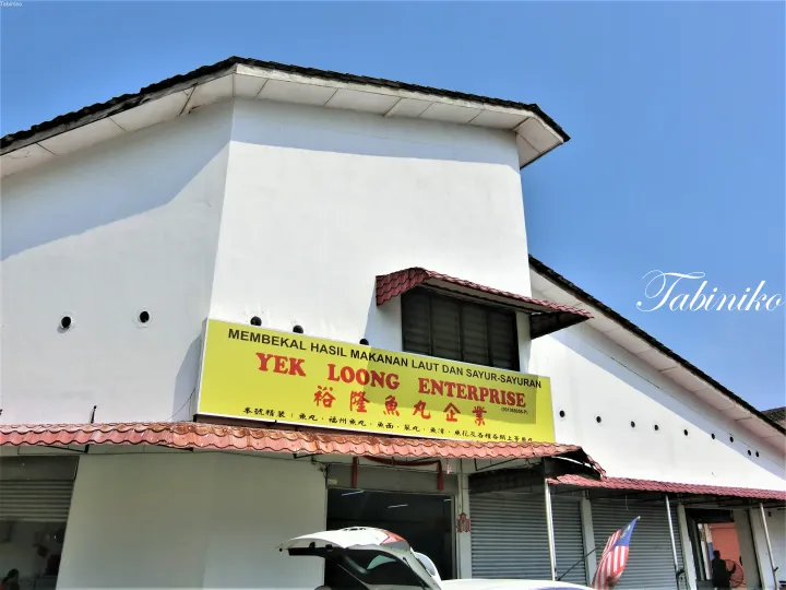 マレーシアの海産物・野菜供給業者「Yek Loong Enterprise」の黄色い看板。