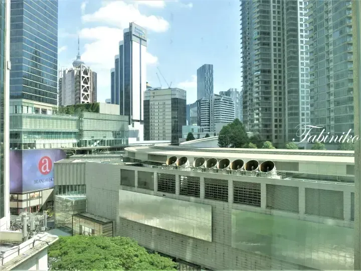 Kuala Lumpur skyline featuring Standard Chartered Bank building and KL Tower in the distance.