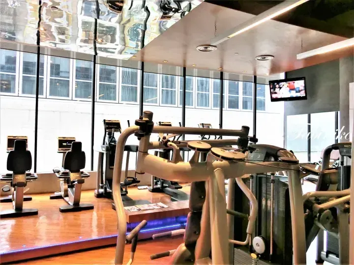 Modern gym interior with cardio machines and city views at a luxury property