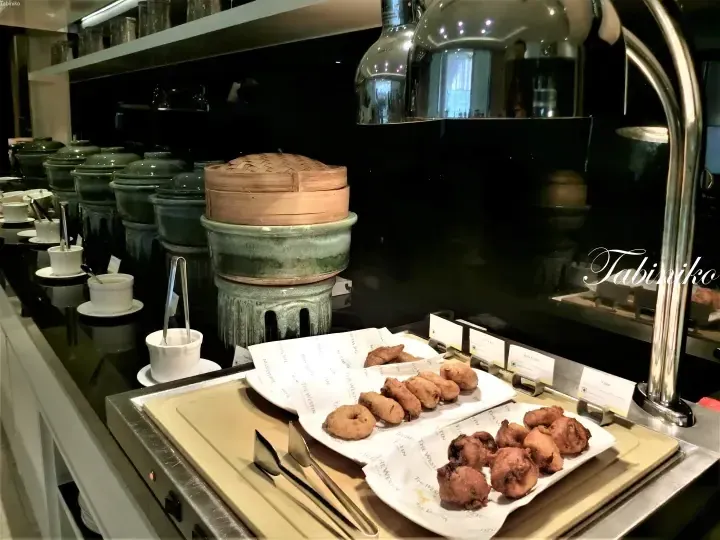 Buffet display at The Westin Kuala Lumpur featuring steamed dim sum and Indian snacks like vadai and roti canai.
