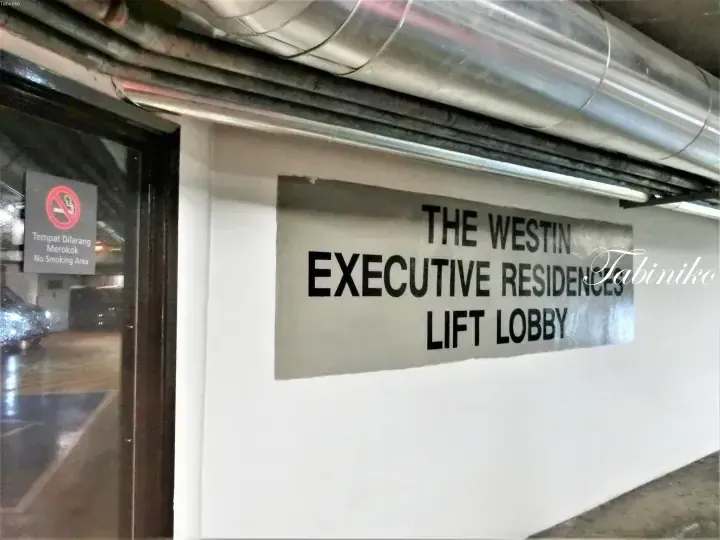 Sign for The Westin Executive Residences lift lobby with a no smoking notice on the glass door.