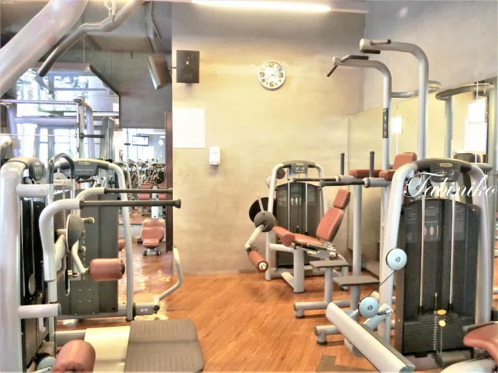 木製床とTechnogym製マシンが整ったモダンなフィットネスルームの内部。
