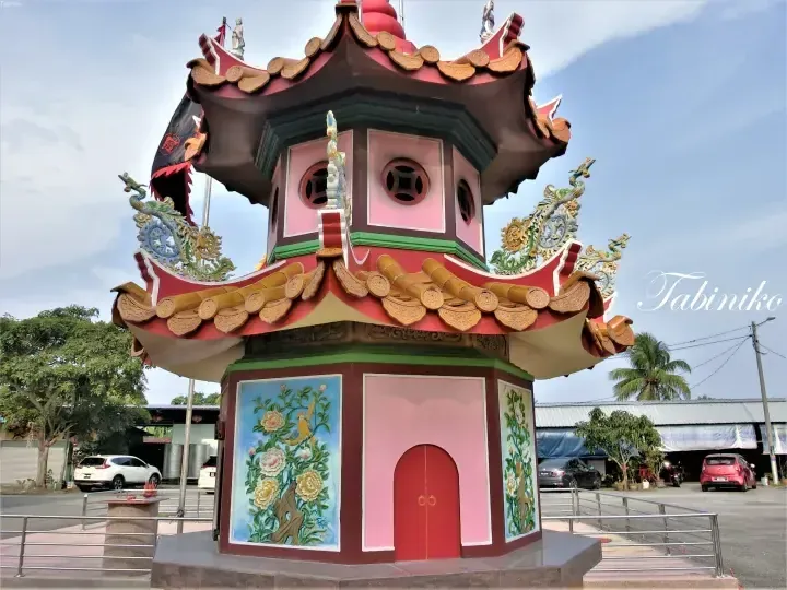 Colorful traditional Chinese-style pavilion with dragon roof ornaments and floral murals in a Malaysian setting.