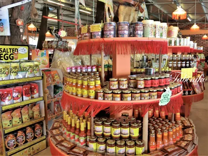 A vibrant display of local Malaysian products including salted egg snacks, chili sauces, and black sesame walnut powder at a specialty food shop.