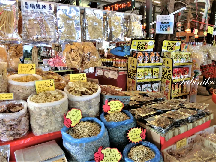 マレーシアの市場で販売されている乾燥魚介類と塩味の卵のお菓子。