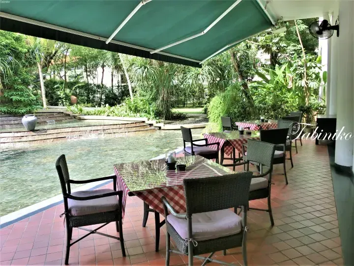 Outdoor dining tables with red checkered tablecloths beside a pool at The Datai Langkawi resort