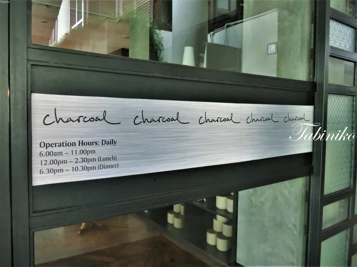 「Charcoal」と書かれた営業時間を示す金属看板。