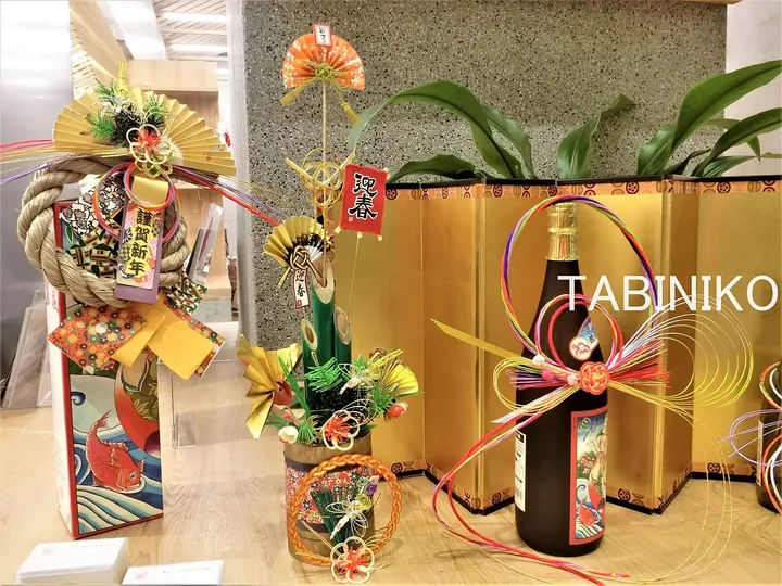 現代のインテリアに展示された、門松や注連縄、日本酒を含む伝統的な日本の正月飾り。