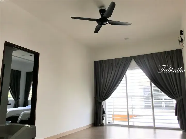 Bright bedroom with grey curtains, ceiling fan, and mirrored wardrobe in a modern Malaysian property.