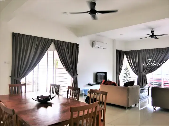 Spacious living and dining area with wooden furniture, grey curtains, and ceiling fans at Tabinil Homestay.