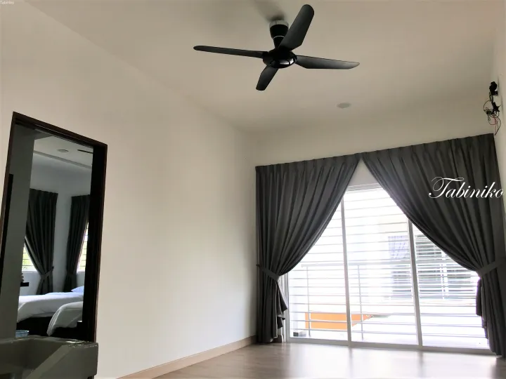 グレーのカーテン、天井扇、鏡付きワードローブを備えたモダンなマレーシアの部屋。