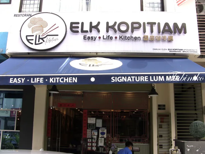 青いオーニングのELK Kopitiamの外観。Easy Life KitchenとSignature Lum Meeの看板が見えます。