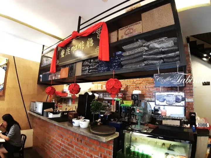 Interior of Ling Lu Coffee House featuring a brick counter, coffee equipment, and red lanterns.