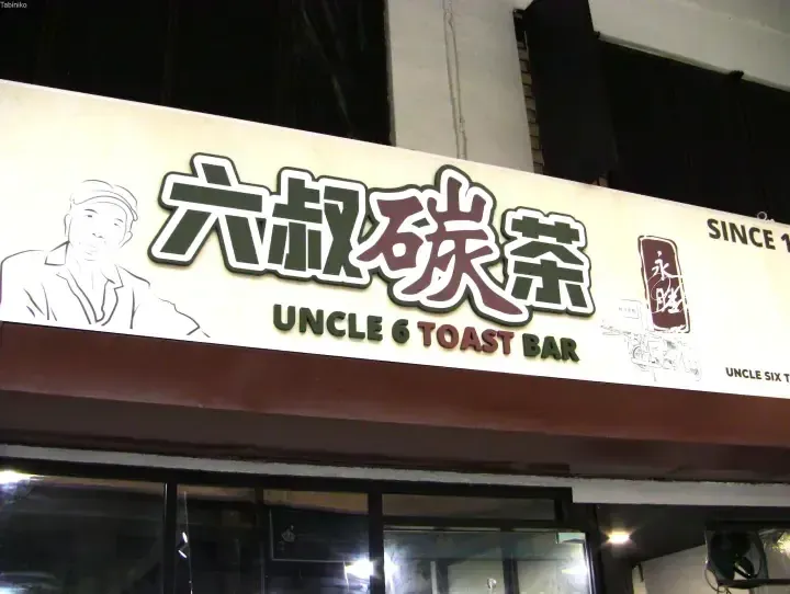 Signage for Uncle 6 Toast Bar featuring Chinese characters and a cartoon illustration of an elderly man.