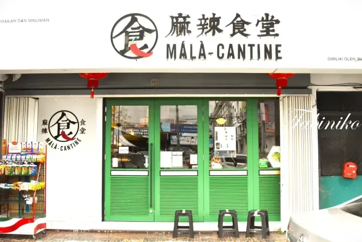 Mala Canteen storefront with green doors, Chinese characters, and red lanterns in Malaysia.