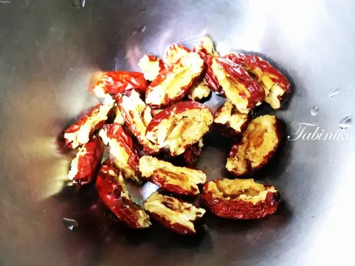 Halved dried red dates in a stainless steel bowl, a common ingredient in Malaysian traditional desserts and soups.