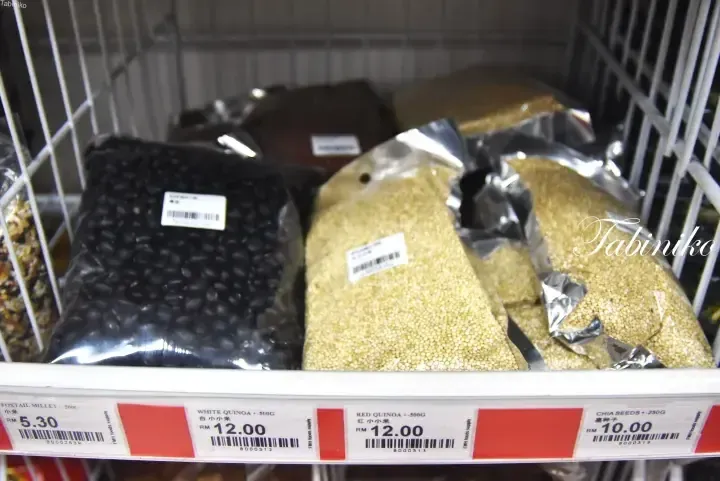 Shelves stocked with packaged Foxtail Millet, White Quinoa, Red Quinoa, and Chia Seeds at a Malaysian grocery store.