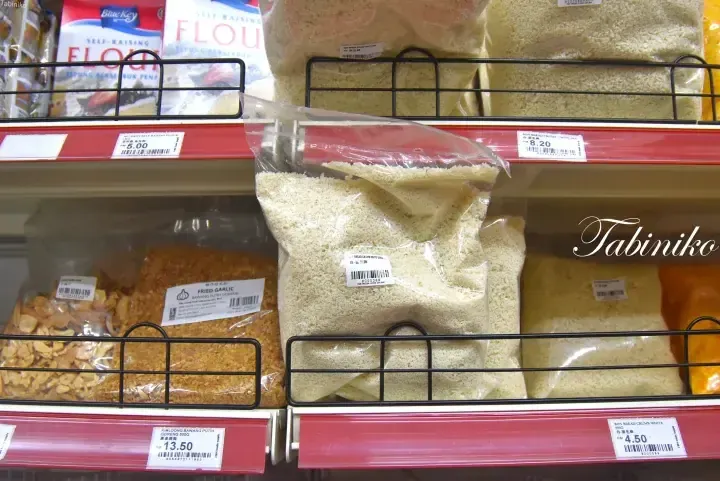 Shelves stocked with Blue Key self-raising flour and Bon bread crumbs at a Malaysian grocery store.
