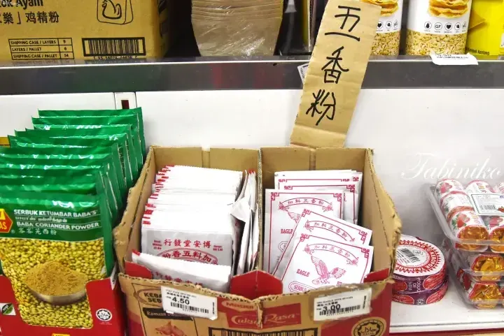 Shelves stocked with Eagle brand five-spice powder and Baba&rsquo;s coriander powder in a Malaysian grocery store.