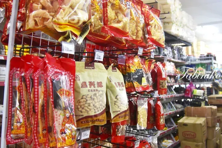 Shelves stocked with various packaged snacks and dried goods at a Malaysian grocery store.
