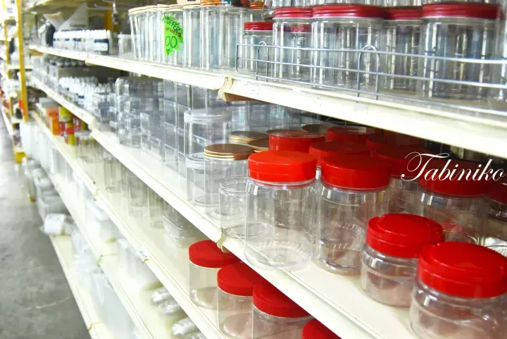 Aisle in a Malaysian baking supply store with shelves stocked with flour, sugar, and ingredients, and customers browsing.