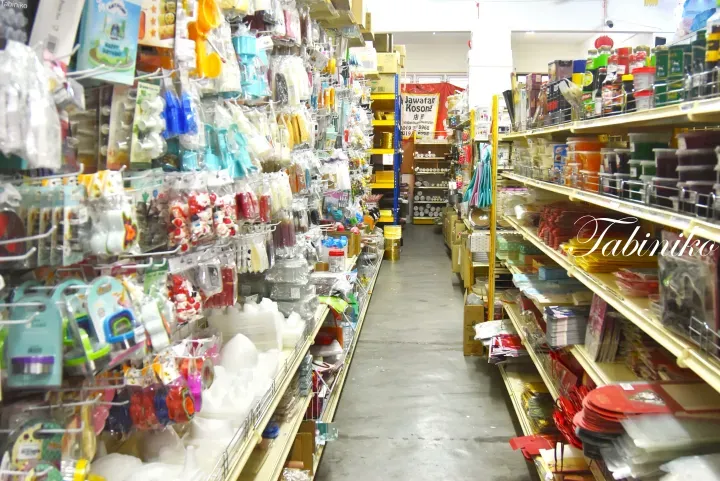 陈列着派对用品、厨房用品和红包的马来西亚杂货店货架过道。
