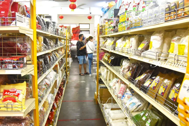小麦粉や砂糖などの材料が並ぶマレーシアのベーキング用品店の店内と客。