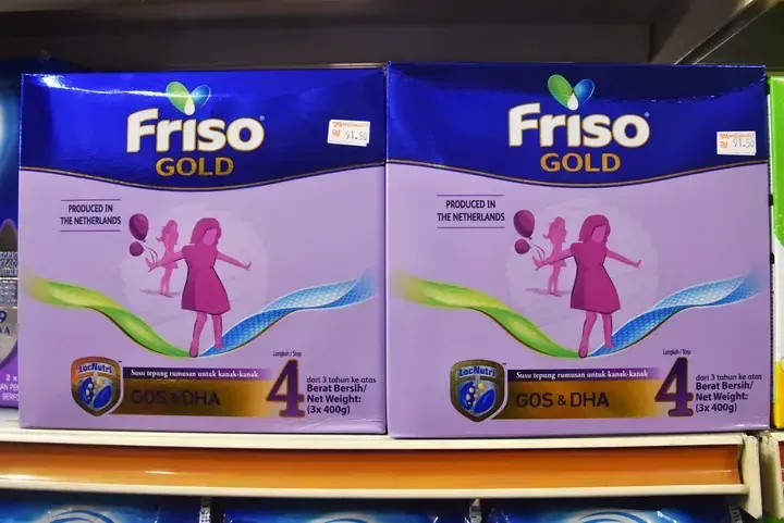 Two boxes of Friso Gold Step 4 milk powder on a supermarket shelf, priced at RM 91.50 each.