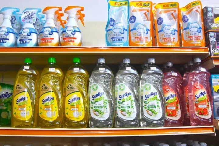 Shelves stocked with Febreze fabric refills and Sunlight dishwashing liquid in various scents at a Malaysian store.