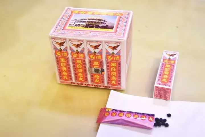Teck Aun Pil Chi Kit Teck Aun traditional medicine boxes and pills displayed on a table.