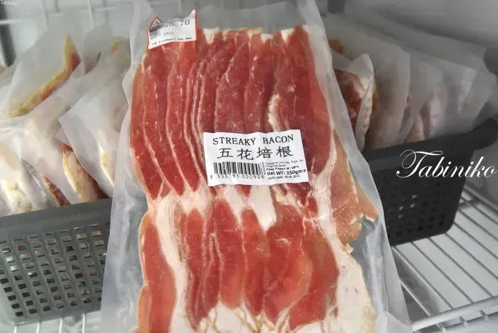 Vacuum-packed streaky bacon labeled 五花培根 in a supermarket freezer display at FS Freshmart.