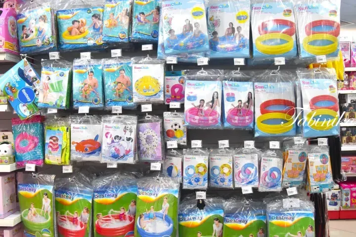 Shelves stocked with Bestway and SunClub inflatable pools and swim rings in a Malaysian retail store.