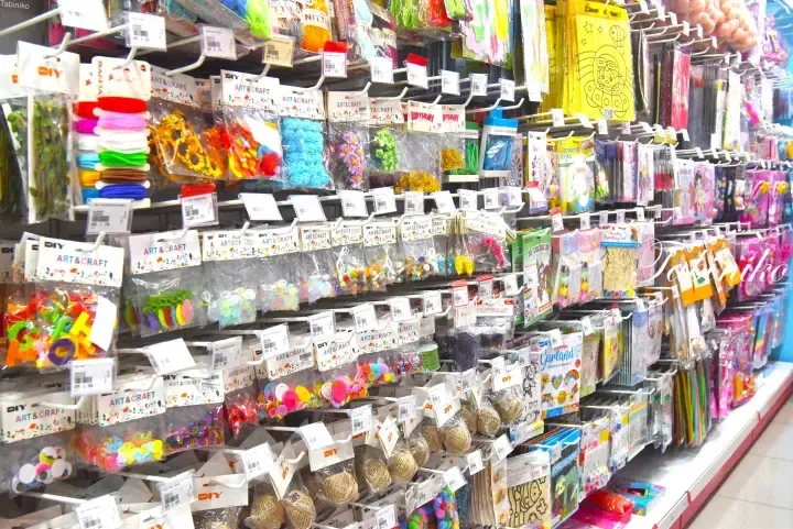 Colorful DIY art and craft supplies displayed on store shelves, including buttons, ribbons, and decorative items.