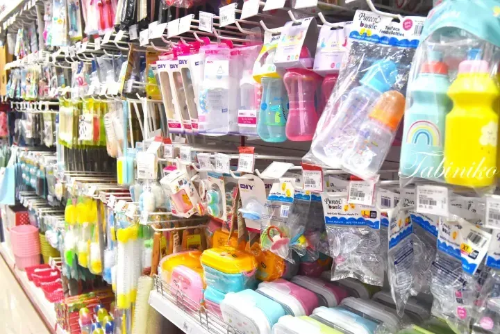 Shelves stocked with baby bottles, pacifiers, and feeding accessories in a store aisle.