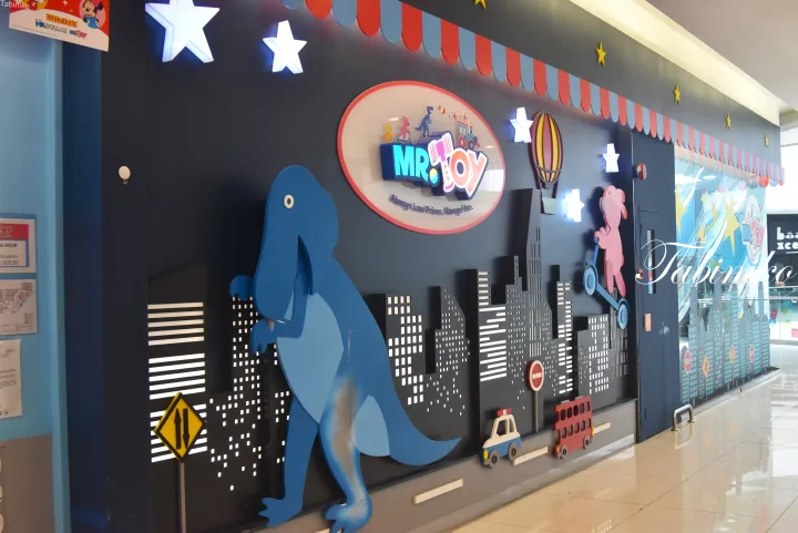 青い恐竜や都市のスカイラインが描かれた「Mr. Toy」の店舗ディスプレイ。
