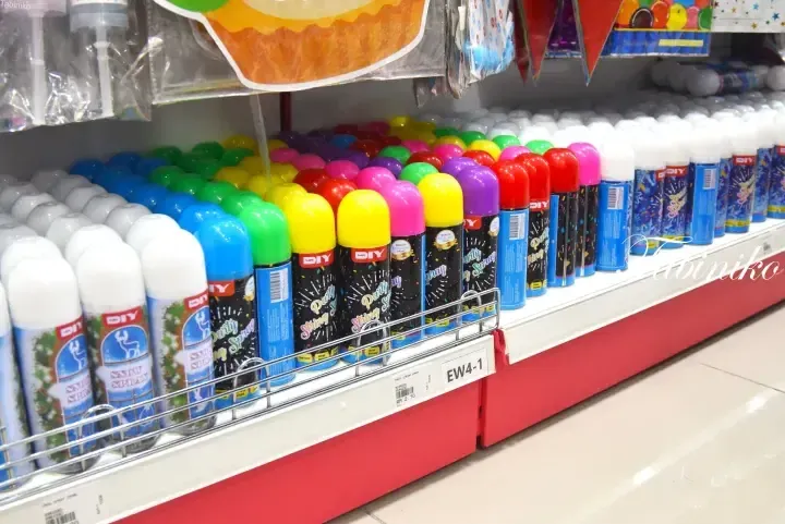 Colorful party string spray and snow spray cans displayed on a shelf at MR DIY in Malaysia.