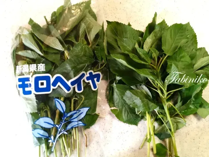 Fresh moroha leaves from Niigata, Japan, packaged for sale and displayed on a kitchen counter.