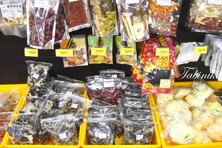 マレーシアの食料品店で、乾燥ハーブや紅棗、キノコなどの食材が棚に並べられている。