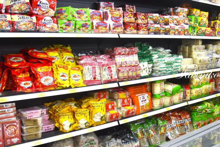 マレーシアのスーパーマーケットで、Mee Suan、Sedaap、Handmade Ramenなどのインスタント麺や乾燥麺が棚に並んでいる様子。