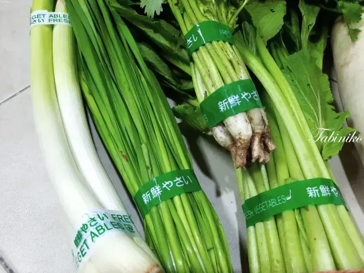 Fresh green vegetables including leeks and spring onions bundled with green bands labeled “Fresh Vegetables” in Japanese.