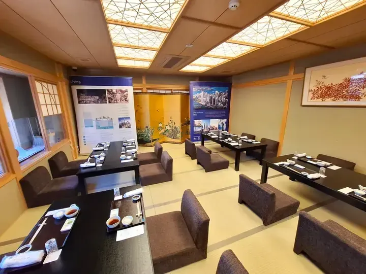 Traditional Japanese dining room with tatami mats, low tables, and promotional banners for The Exchange TRX and Lendlease.