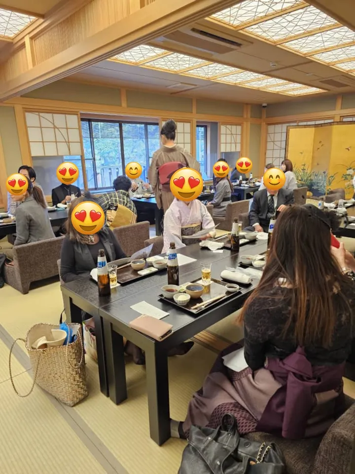 畳と低いテーブルが並ぶ伝統的な日本料理店で、客が食事を楽しんでいる様子。