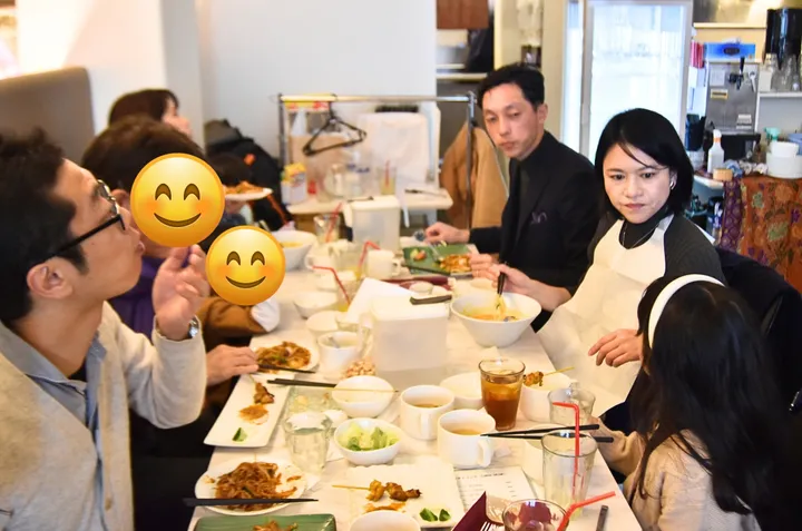 食卓を囲んで食事を楽しむ友人たちの様子。