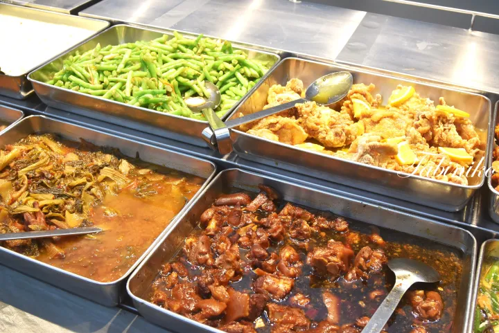 マレーシアの屋台で提供される、緑豆、レモンチキン、煮込み野菜、豚足などの料理が並ぶビュッフェのトレイ。