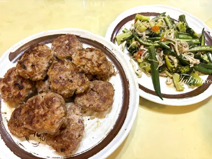 Homemade beef patties and stir-fried vegetables served on ceramic plates