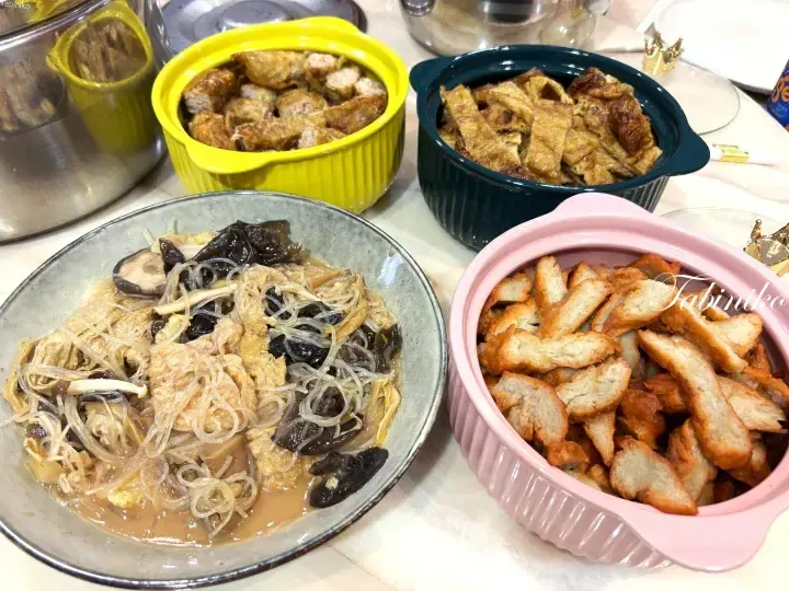 Colorful bowls of Malaysian vegetarian dishes including fried tofu, glass noodles with mushrooms, and braised tofu puffs.
