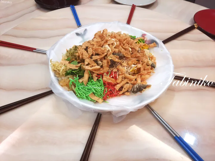 食卓に置かれた、トッピングをたっぷり乗せたカラフルなユッシェン(生魚のサラダ)の盛り合わせ。