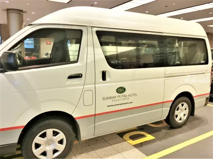 White Sunway Putra Hotel shuttle van parked at the entrance in Kuala Lumpur.