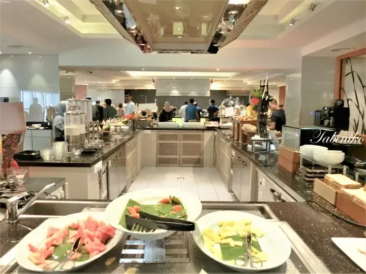 Buffet spread featuring fresh papaya and pineapple at a hotel dining area in Malaysia.